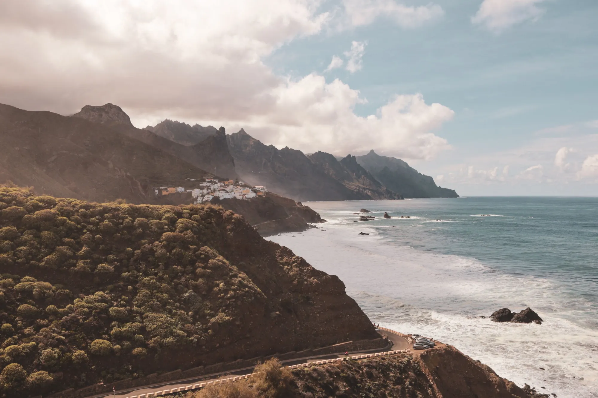 Jagged green ridges of the Anaga mountains above the Atlantic, with the village of Taganana